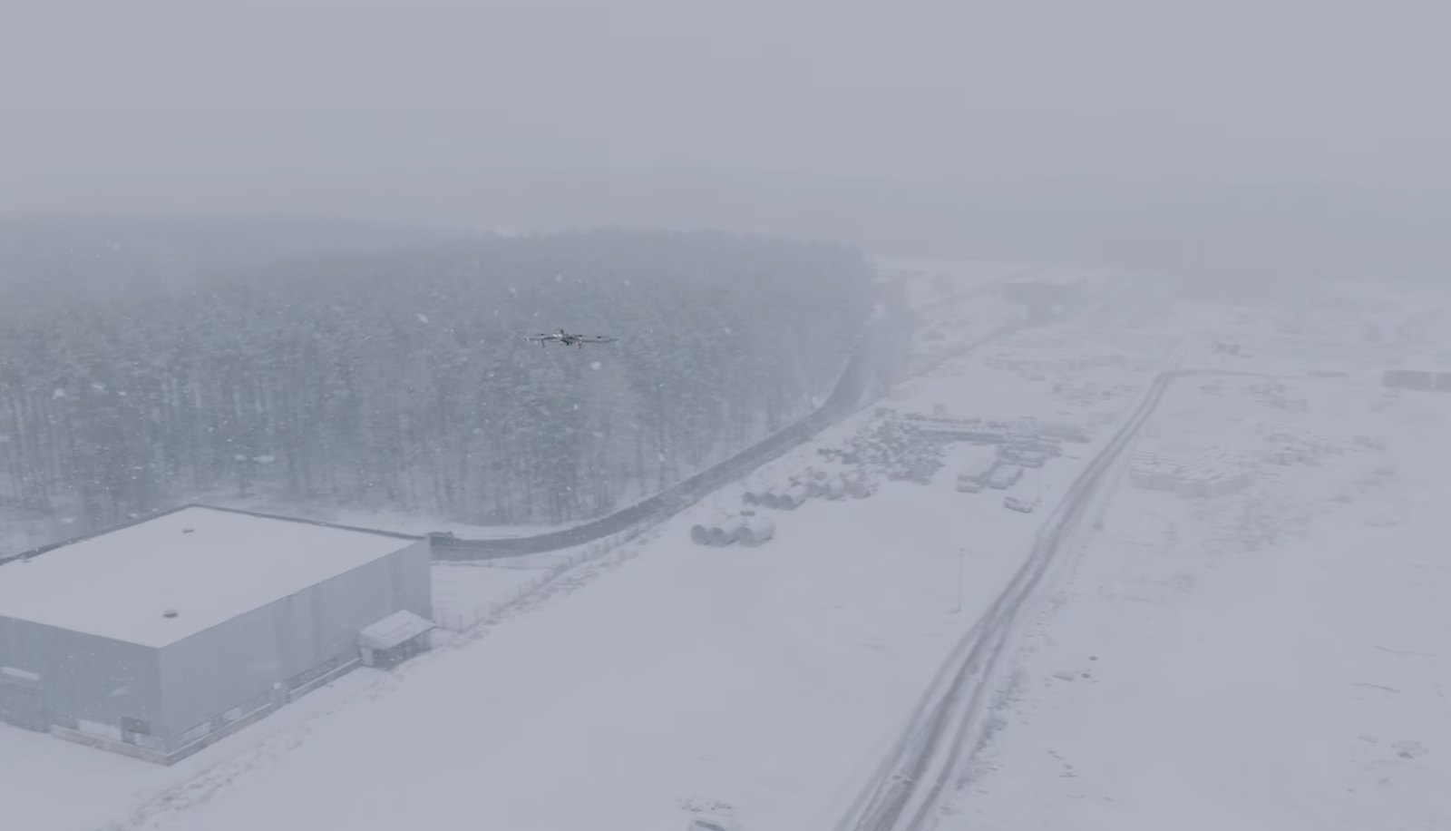 Autonomous drone patrolling a large industrial site in a snowstorm